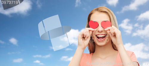 Image of happy young woman with red heart shapes on eyes