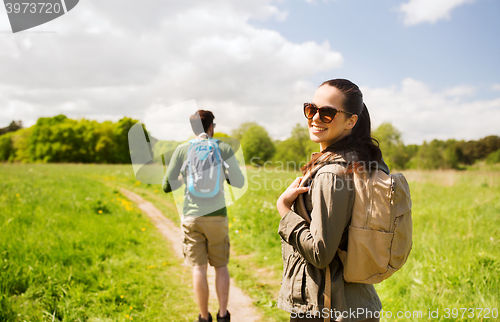 Image of happy couple with backpacks hiking outdoors