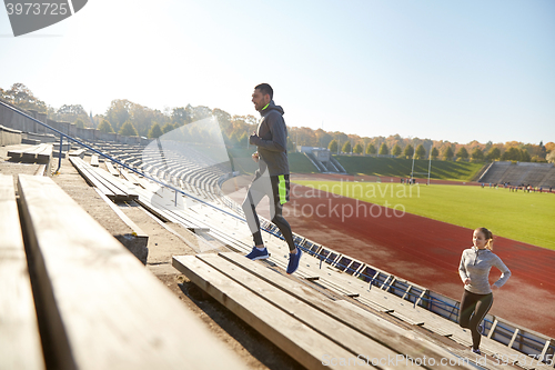 Image of happy couple running upstairs on stadium