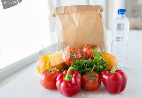 Image of basket of fresh vegetables and water at kitchen