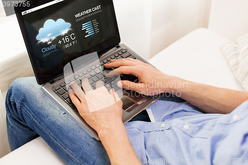 Image of close up of man typing on laptop computer at home
