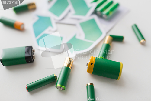 Image of close up of batteries and green recycling symbol