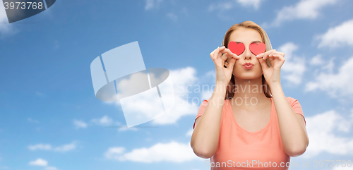 Image of happy young woman with red heart shapes on eyes