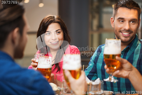 Image of friends dining and drinking beer at restaurant