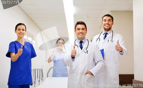 Image of happy doctors showing thumbs up at hospital