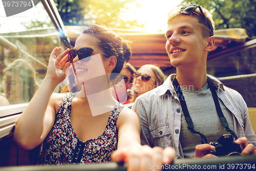 Image of smiling couple with camera traveling by tour bus