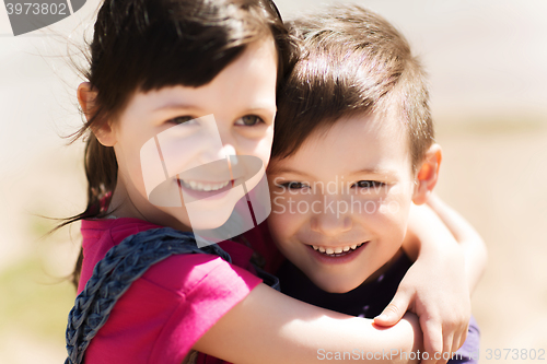 Image of two happy kids hugging outdoors