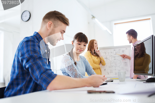 Image of creative team with blueprint at office