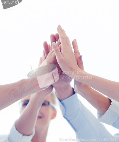 Image of happy business team giving high five in office