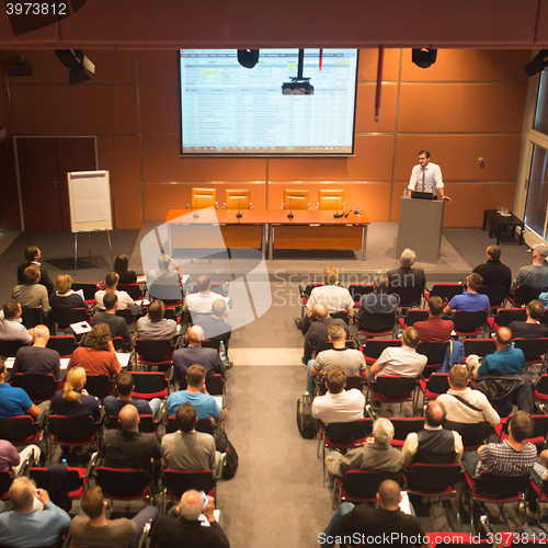 Image of Business speaker giving a talk in conference hall.