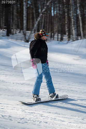 Image of Woman doing exercise on snowboard in sunny day