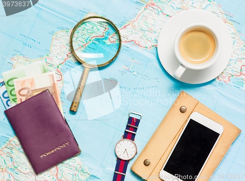 Image of Preparation for travel concept - map, magnifying glass, cup of coffee, notepad, phone
