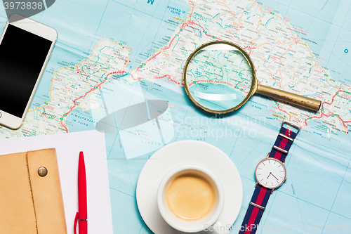 Image of Preparation for travel concept - map, magnifying glass, cup of coffee, notepad, phone