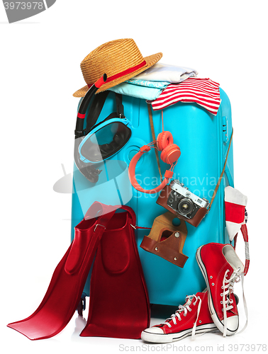 Image of The blue suitcase, sneakers, clothing, hat, and retro camera on white background.