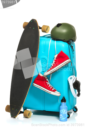 Image of The blue suitcase, sneakers, skateboard on white background.