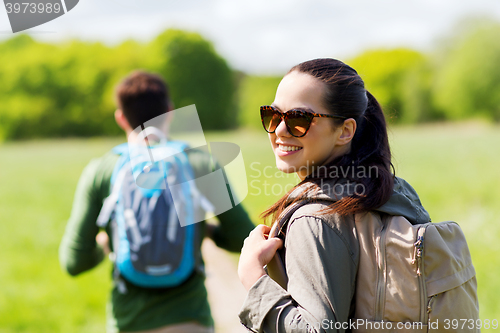 Image of happy couple with backpacks hiking outdoors