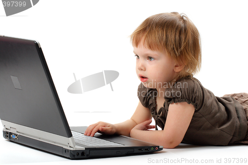 Image of Small girl lieing and learning at notebook