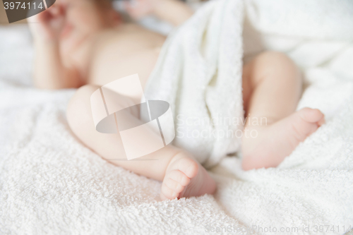 Image of newborn tiny baby lying on the bed with blanket