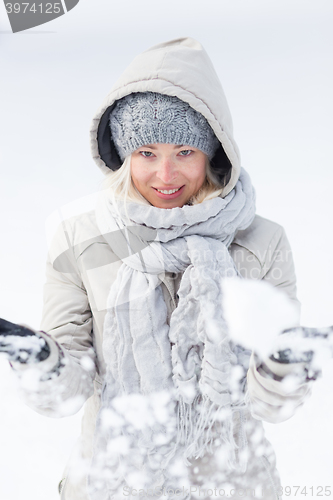 Image of Girl  playing with snow in winter.