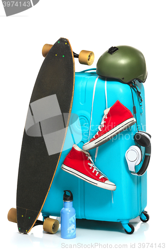 Image of The blue suitcase, sneakers, skateboard on white background.