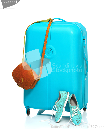 Image of The blue suitcase, sneakers, handbag on white background.