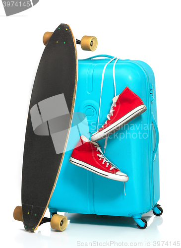 Image of The blue suitcase, sneakers, skateboard on white background.