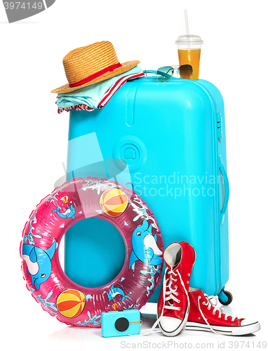 Image of The blue suitcase, sneakers, hat and rubber ring on white background.