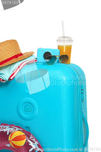 Image of The blue suitcase, sneakers, hat and rubber ring on white background.