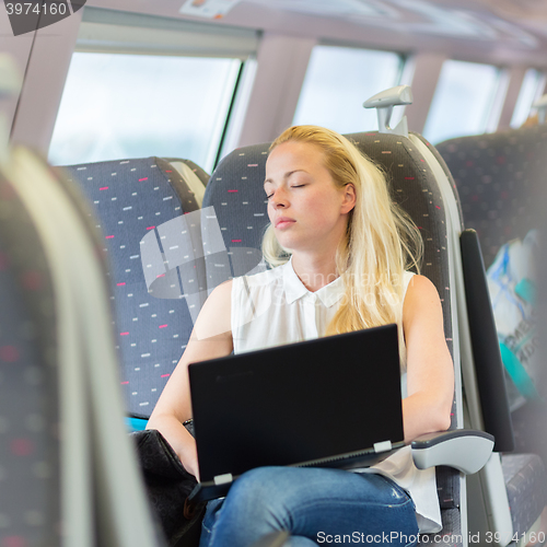 Image of Woman sleeping while travelling by train.