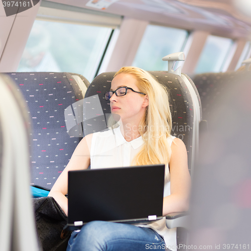 Image of Woman naping while travelling by train.