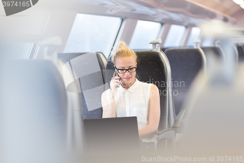 Image of Business woman working while travelling by train.