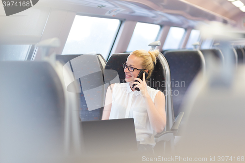 Image of Business woman working while travelling by train.