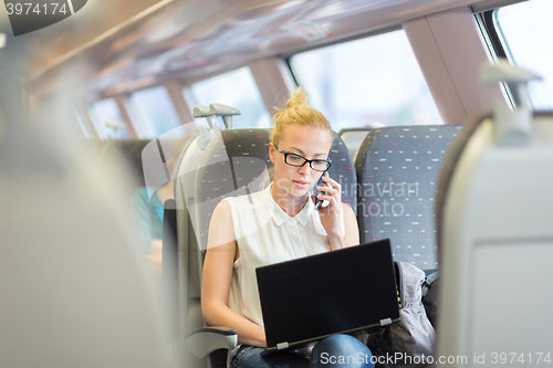 Image of Business woman working while travelling by train.