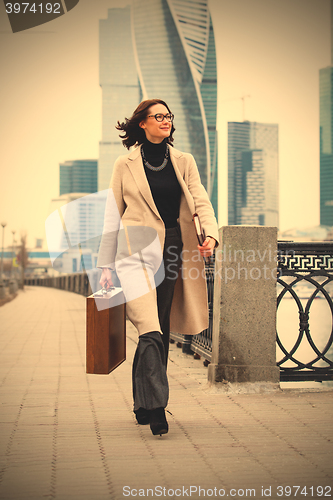 Image of smiling woman with a case and books