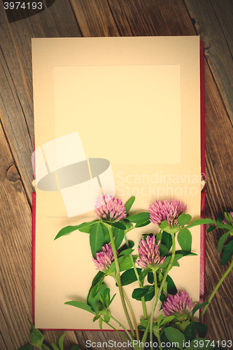 Image of blank photo album and clover flowers