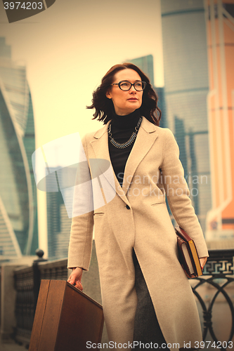 Image of beautiful woman in a white coatin the city\'s business district