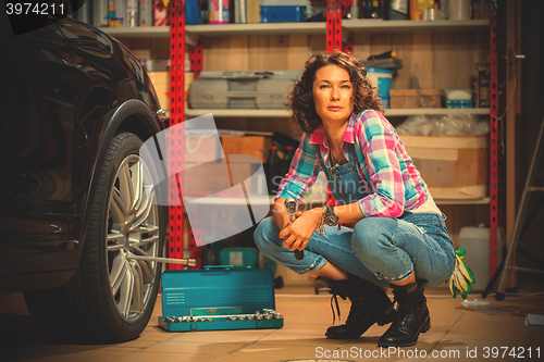 Image of smiling woman mechanic in overalls