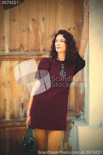 Image of attractive middle-aged woman in a burgundy dress 