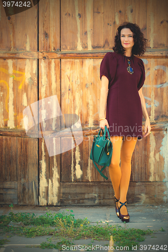 Image of beautiful middle-aged brunette in burgundy dress