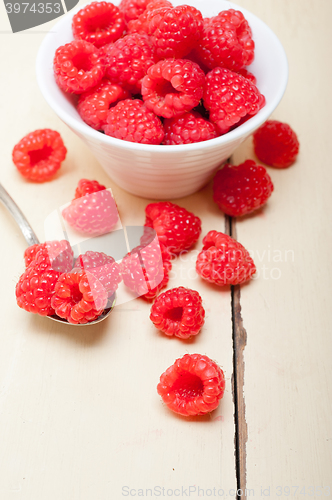 Image of bunch of fresh raspberry on a bowl and white table