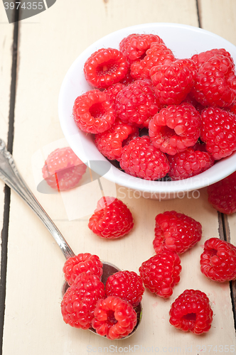 Image of bunch of fresh raspberry on a bowl and white table