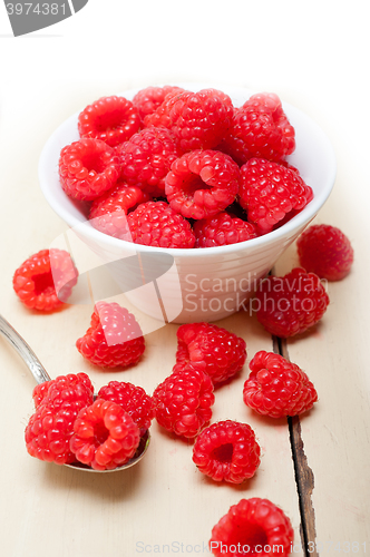 Image of bunch of fresh raspberry on a bowl and white table