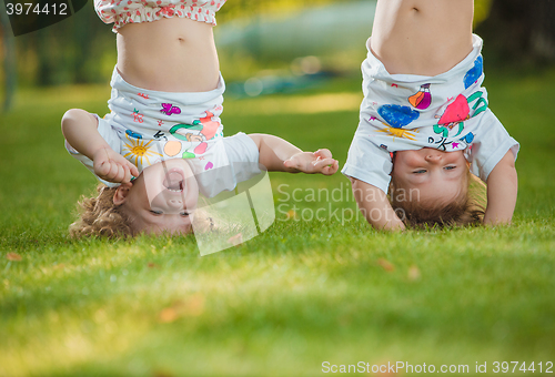 Image of The two little baby girls hanging upside down