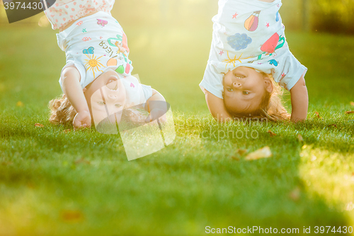 Image of The two little baby girls hanging upside down