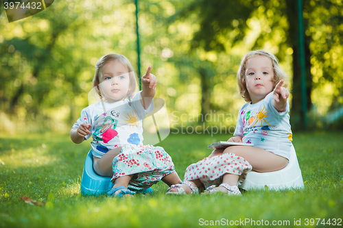 Image of The two little baby girls hanging upside down