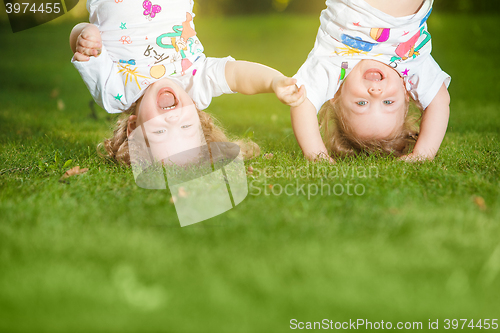 Image of The two little baby girls hanging upside down