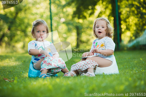 Image of The two little baby girls hanging upside down