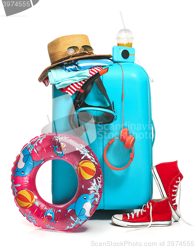 Image of The blue suitcase, sneakers, hat and rubber ring on white background.