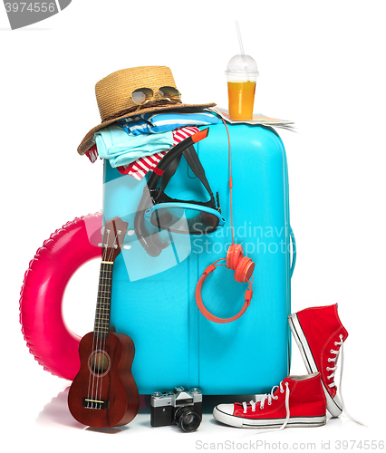 Image of The blue suitcase, sneakers, hat and rubber ring on white background.