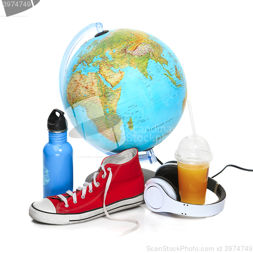 Image of The blue globe, sneakers, thermos and headphones on white background.